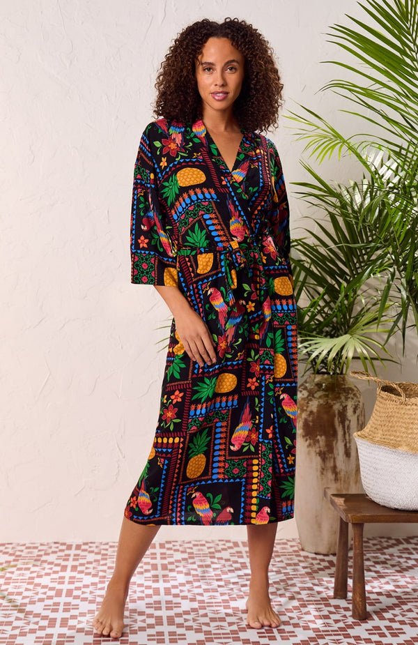 A lady wearing black short sleeve Lydia Maxi Robe with Tropical Fiesta print.