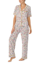 A lady wearing white short sleeve Vienna Pj Set with  Oopsy Daisy  print.