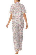 A lady wearing white short sleeve Vienna Pj Set with  Oopsy Daisy  print.