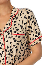 A lady wearing tan short sleeve teagan pj set with desert dots print.