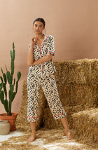 A lady wearing tan short sleeve teagan pj set with desert dots print.