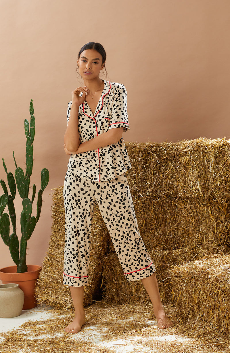 A lady wearing tan short sleeve teagan pj set with desert dots print.