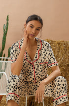 A lady wearing tan short sleeve teagan pj set with desert dots print.