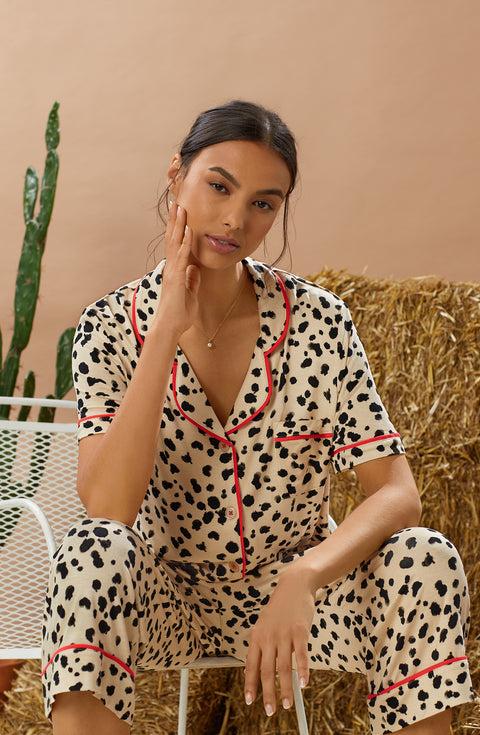 A lady wearing tan short sleeve teagan pj set with desert dots print.