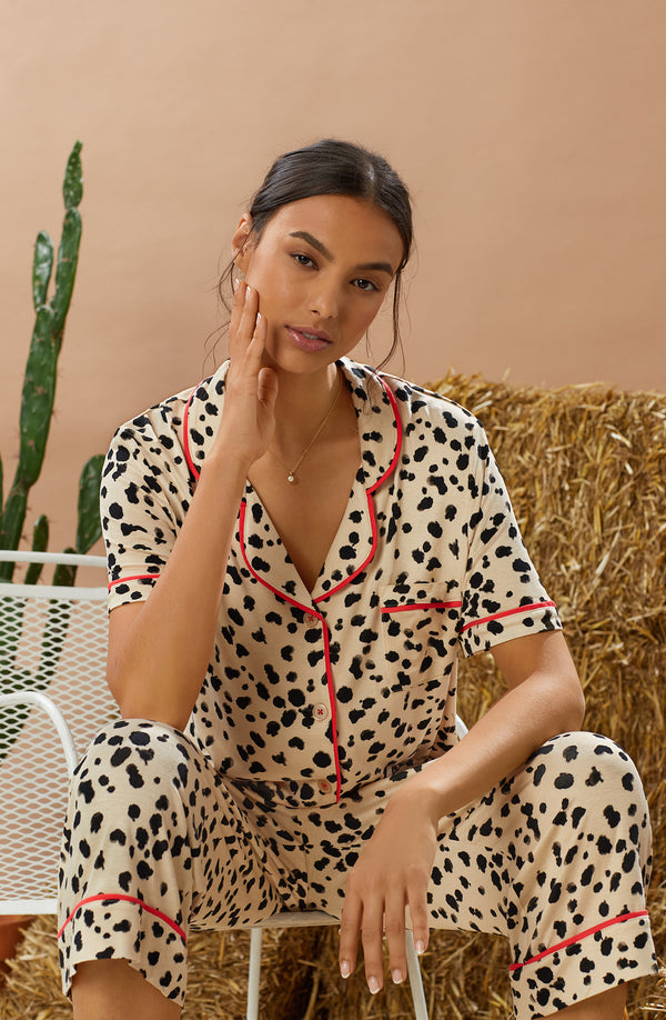 A lady wearing tan short sleeve teagan pj set with desert dots print.