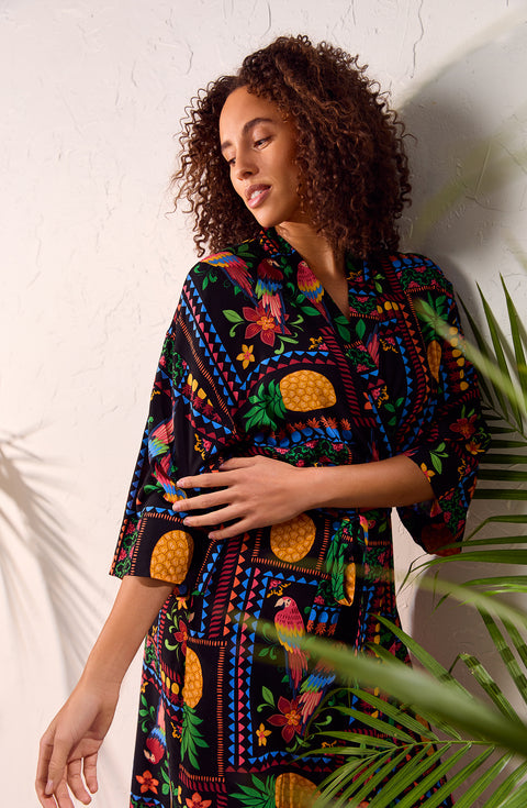 A lady wearing black short sleeve Lydia Maxi Robe with Tropical Fiesta print.