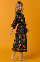 A lady wearing black short sleeve Lydia Maxi Robe with Tropical Fiesta print.