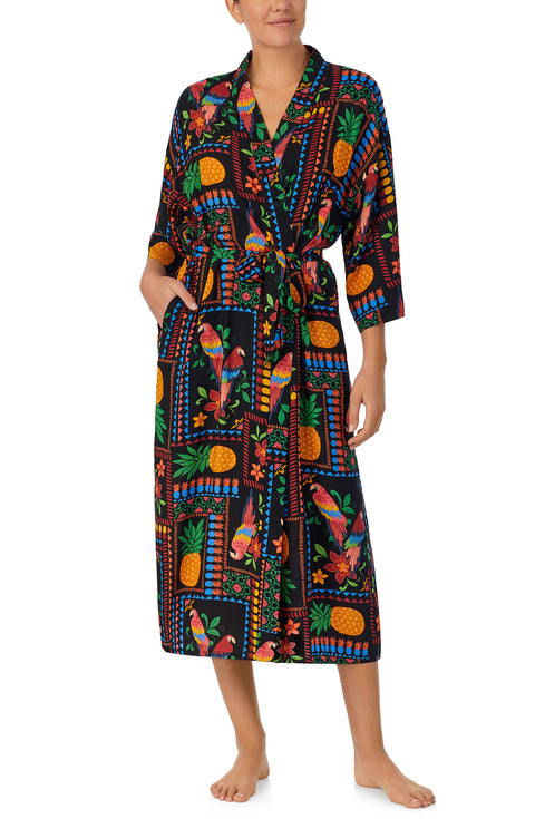 A lady wearing black short sleeve Lydia Maxi Robe with Tropical Fiesta print.