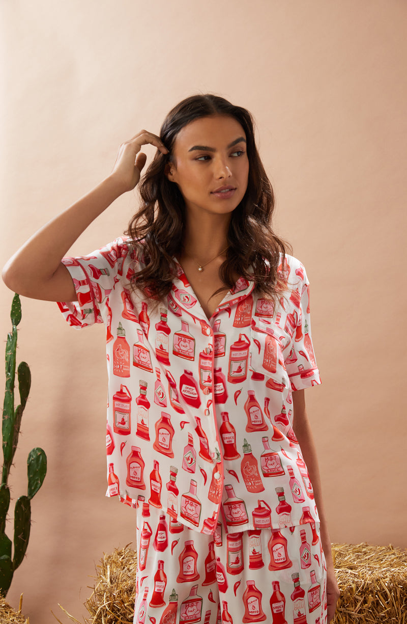 A lady wearing white short sleeve chelsea pj set with hot stuff print.