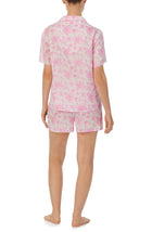 A lady wearing pink short sleeve florence pj set in Sweetheart Floral with flowers print.