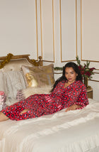 A Lady Wearing Risa Chenille Robe In Wild Spots & Stripes while relaxing and lying on a bed