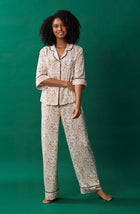 A lady wearing white quarter sleeve gramercy pj set with golden gaze print.