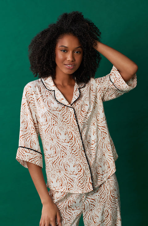 A lady wearing white quarter sleeve gramercy pj set with golden gaze print.