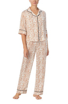 A lady wearing white quarter sleeve gramercy pj set with golden gaze print.