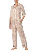 A lady wearing white quarter sleeve gramercy pj set with golden gaze print.