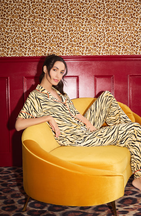 A Lady Wearing Sienna Long Knit Pj Set In Tiger Glam posing while sitting on a sofa