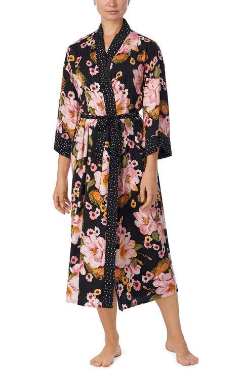 A lady wearing black long sleeve lydia maxi robe with midnight magnolia print.