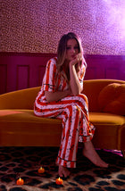 A Lady Wearing Sienna Long Knit Pj Set In Haunted Happy Hour sitting on a sofa