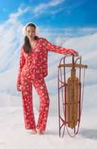 A Lady Wearing Collette Knit Pj Set In Country Claus standing in a snowy winter setup