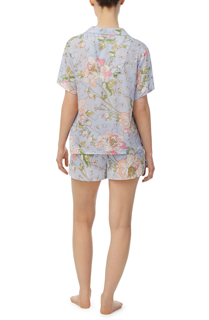 A lady wearing blue short sleeve florence pj set in blooming bride.