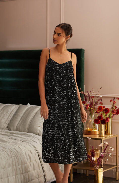 A lady wearing black sleeveless addison maxi slip with on the dot print.