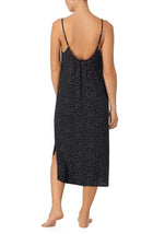 A lady wearing black sleeveless addison maxi slip with on the dot print.