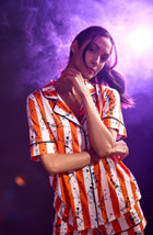 A Lady Wearing Siennna Short Knit Pj Set In Haunted Happy Hour in a purple smoky background