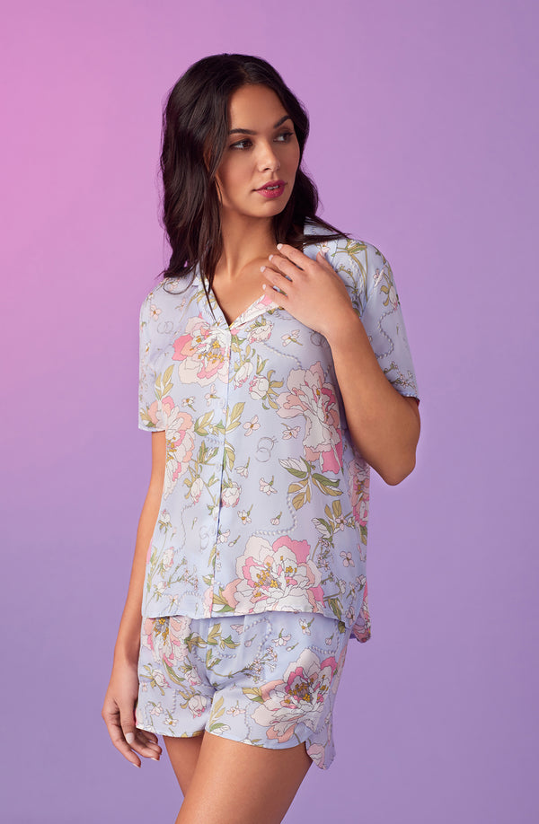 A lady wearing blue short sleeve florence pj set in blooming bride.