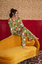 A Lady Wearing Stella Knit Pj Set In Autumn Blooms sitting elegantly on a yellow sofa in a sophisticated relaxed pose