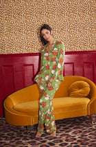 A Lady Wearing Stella Knit Pj Set In Autumn Blooms standing in a front facing pose in front of a yellow sofa