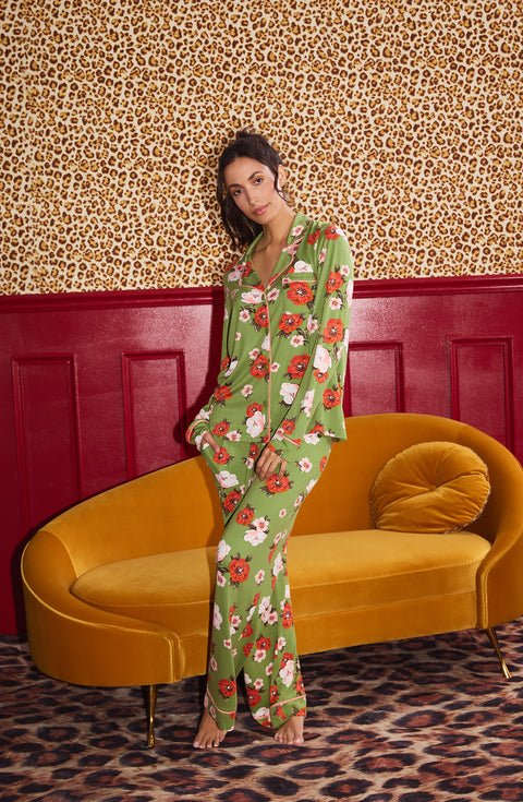 A Lady Wearing Stella Knit Pj Set In Autumn Blooms standing in a front facing pose in front of a yellow sofa