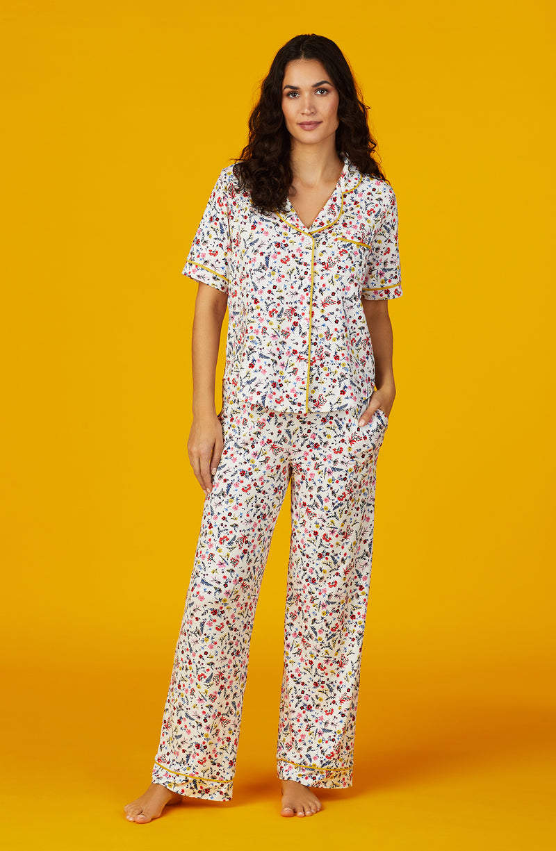 A lady wearing white short sleeve Vienna Pj Set with  Oopsy Daisy  print.