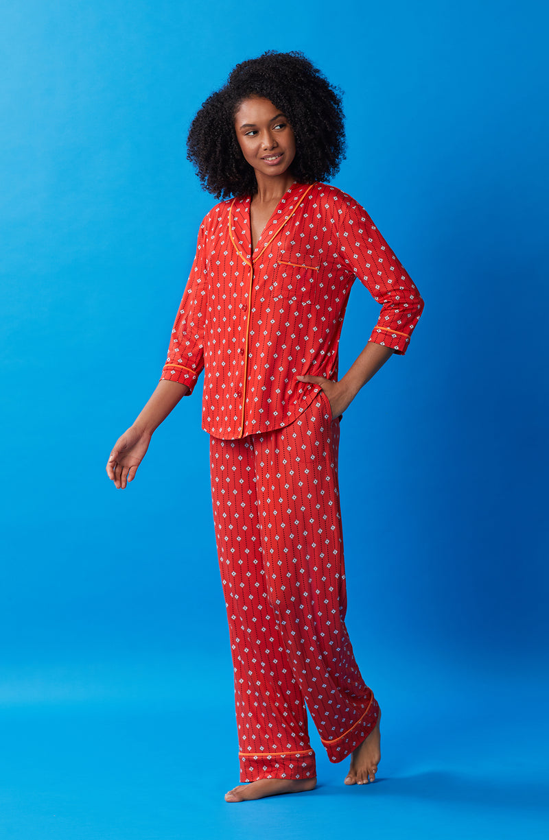 A lady wearing orange quarter sleeve reagent pj set with daisy dots print.