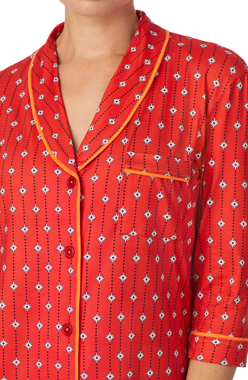 A lady wearing orange quarter sleeve reagent pj set with daisy dots print.