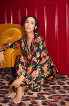 A Lady Wearing Stella Knit Pj Set In Flora & Fierce sitting elegantly on a leopard print floor