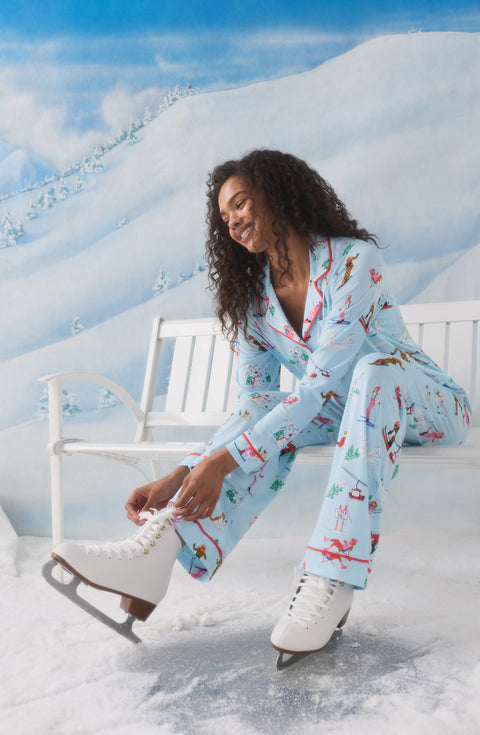 A Lady Wearing Collette Knit Pj Set In Champagne Slopes wearing stylish winter snow skating boots