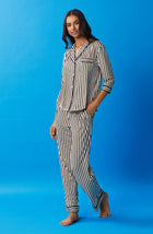 A lady wearing black and white reagent pj set with midnight stripe print.