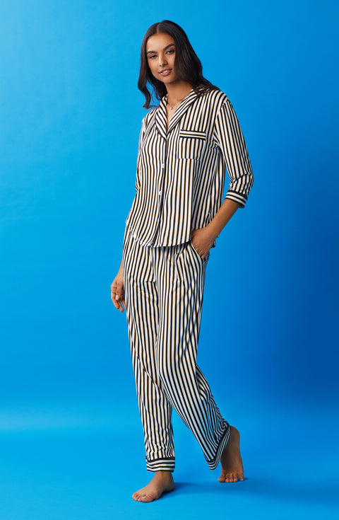A lady wearing black and white reagent pj set with midnight stripe print.