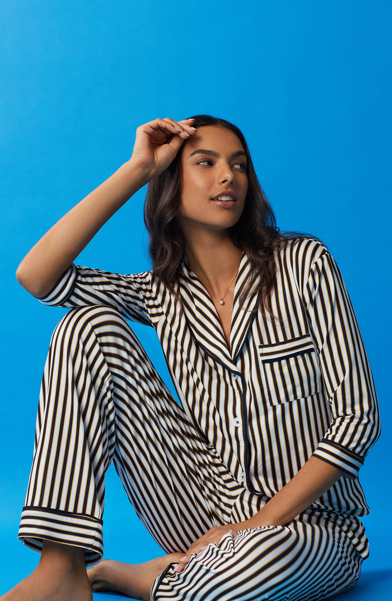A lady wearing black and white reagent pj set with midnight stripe print.
