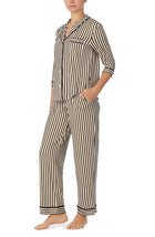 A lady wearing black and white reagent pj set with midnight stripe print.