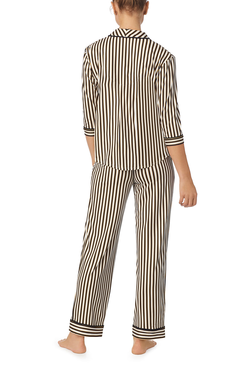 A lady wearing black and white reagent pj set with midnight stripe print.