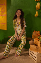 A Lady Wearing Dakota Long Knit Pj Set In Lemonade Stand Stripe shown in a front facing sitting pose