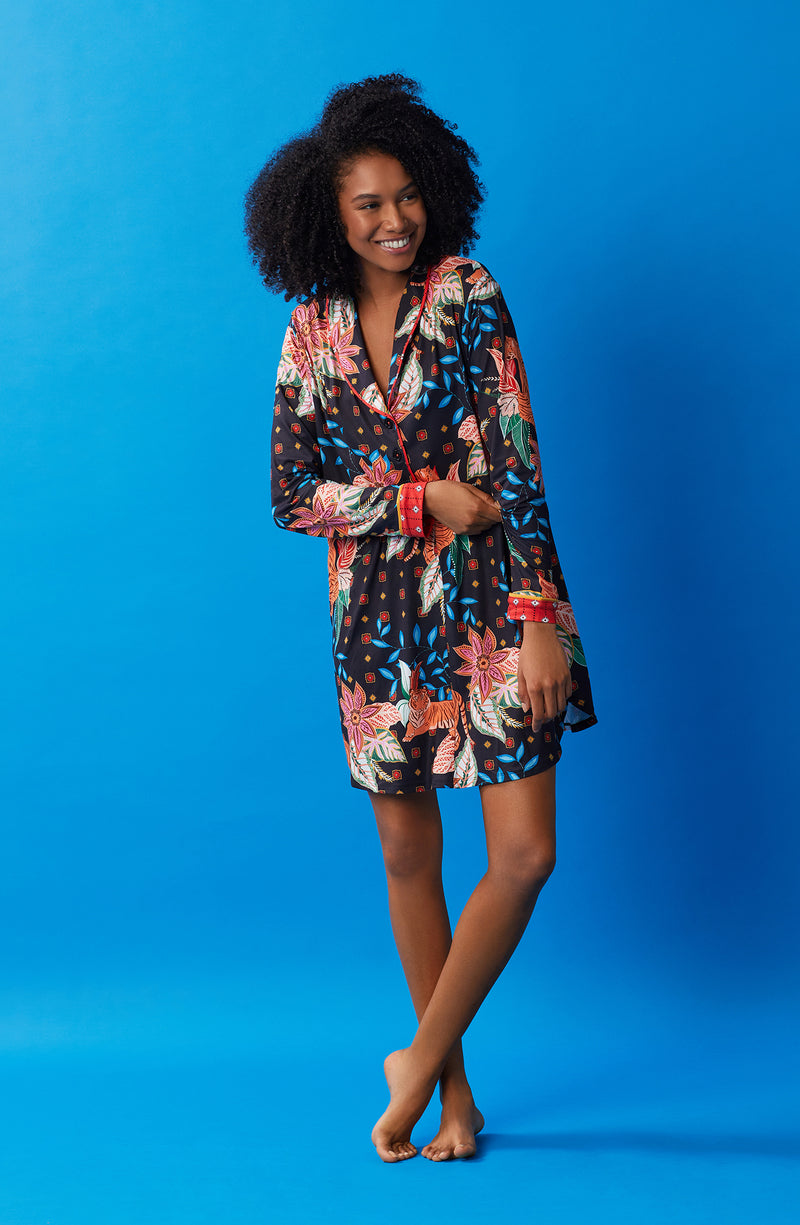 A lady wearing black long sleeve sutton sleepshirt with jungle blooms.
