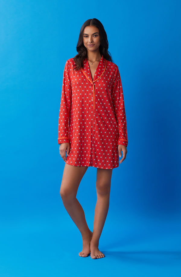 A lady wearing orange sutton sleepshirt with daisy dots print.