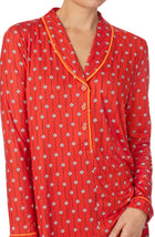 A lady wearing orange sutton sleepshirt with daisy dots print.