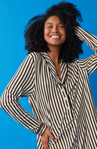 A lady wearing black and white sutton sleepshirt with midnight stripe print.
