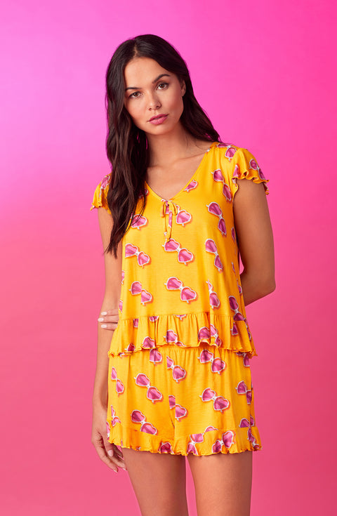 A lady wearing yellow cap sleeve phoebe pj set in sunny honey.