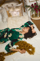 A Lady Wearing Risa Chenille Robe In Panthera Glam while relaxing and lying on a bed