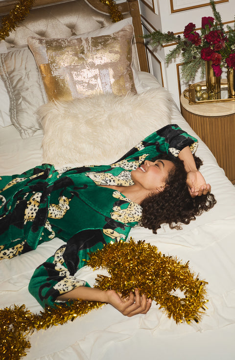 A Lady Wearing Risa Chenille Robe In Panthera Glam while relaxing and lying on a bed