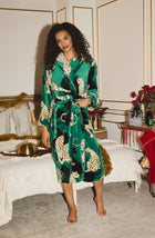 A Lady Wearing Risa Chenille Robe In Panthera Glam standing in a room in front of a bed